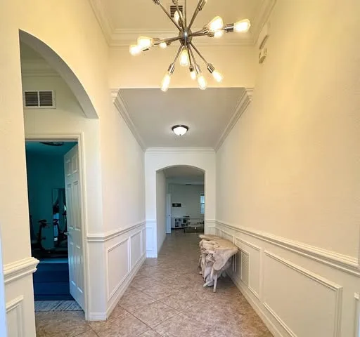Hallway with wainscoting and crown molding